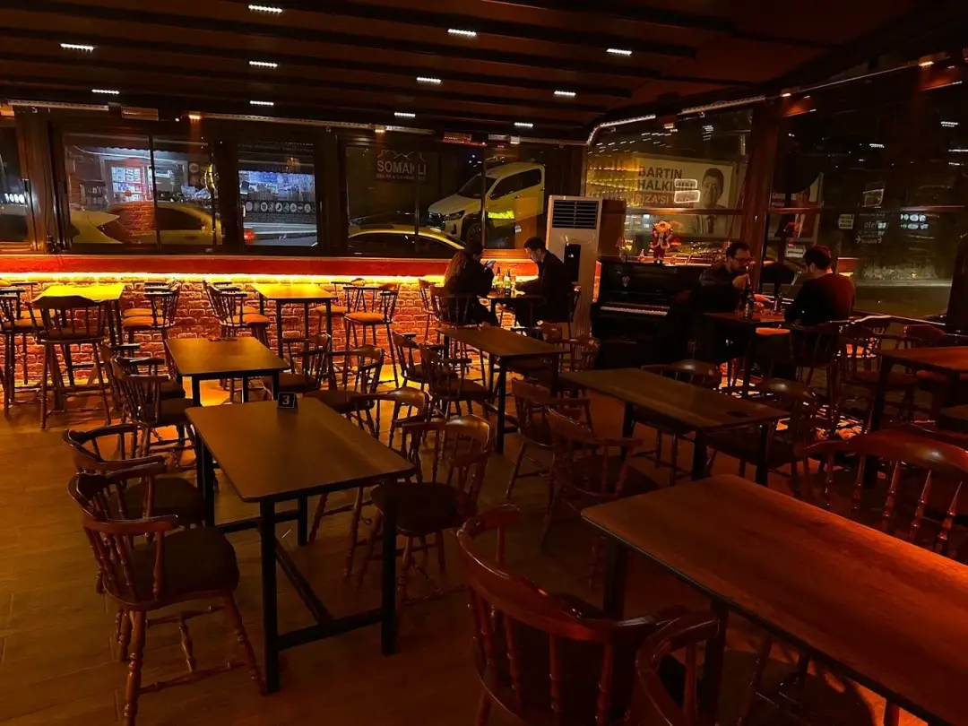 Rustic Pub & Bistro salonu: ahşap masalar ve tuğla duvar boyunca amber ışık