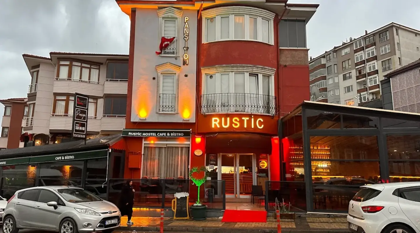 Rustic Hotel’in kırmızı-beyaz cephesi ve ışıklı RUSTIC tabelası, Kırtepe / Bartın
