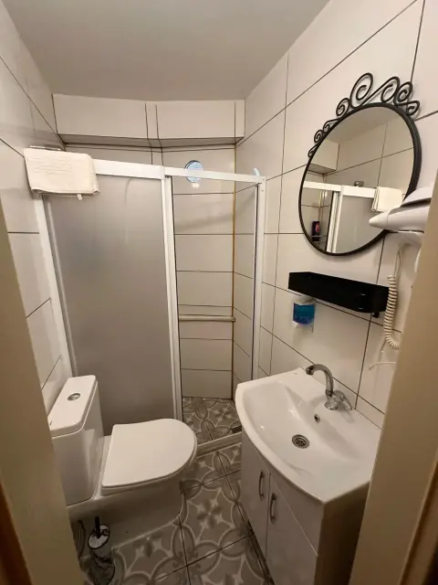 Oda banyosu: duşakabin, lavabo ve temiz havlular